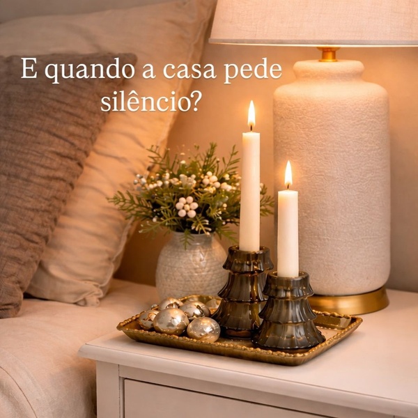 A close-up, warm-toned image of two glass candle holders with lit candles and a bedside lamp, emphasizing a calm and cozy home environment.
