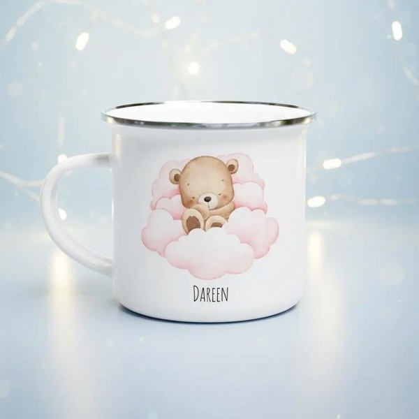A high-quality 1:1 ratio studio shot of a white enamel mug featuring a customized teddy bear design on a soft-focus background.